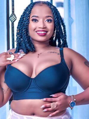 Plus size woman wearing a black longline bra and high-waist lace panties in soft pink, showing front details of the lingerie set."