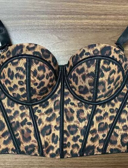 Women's leopard print bustier corset top with padded cups, black boning, and adjustable shoulder straps, displayed flat on a wooden surface. Stylish fitted corset for parties, date nights, and fashion wear in Kenya.